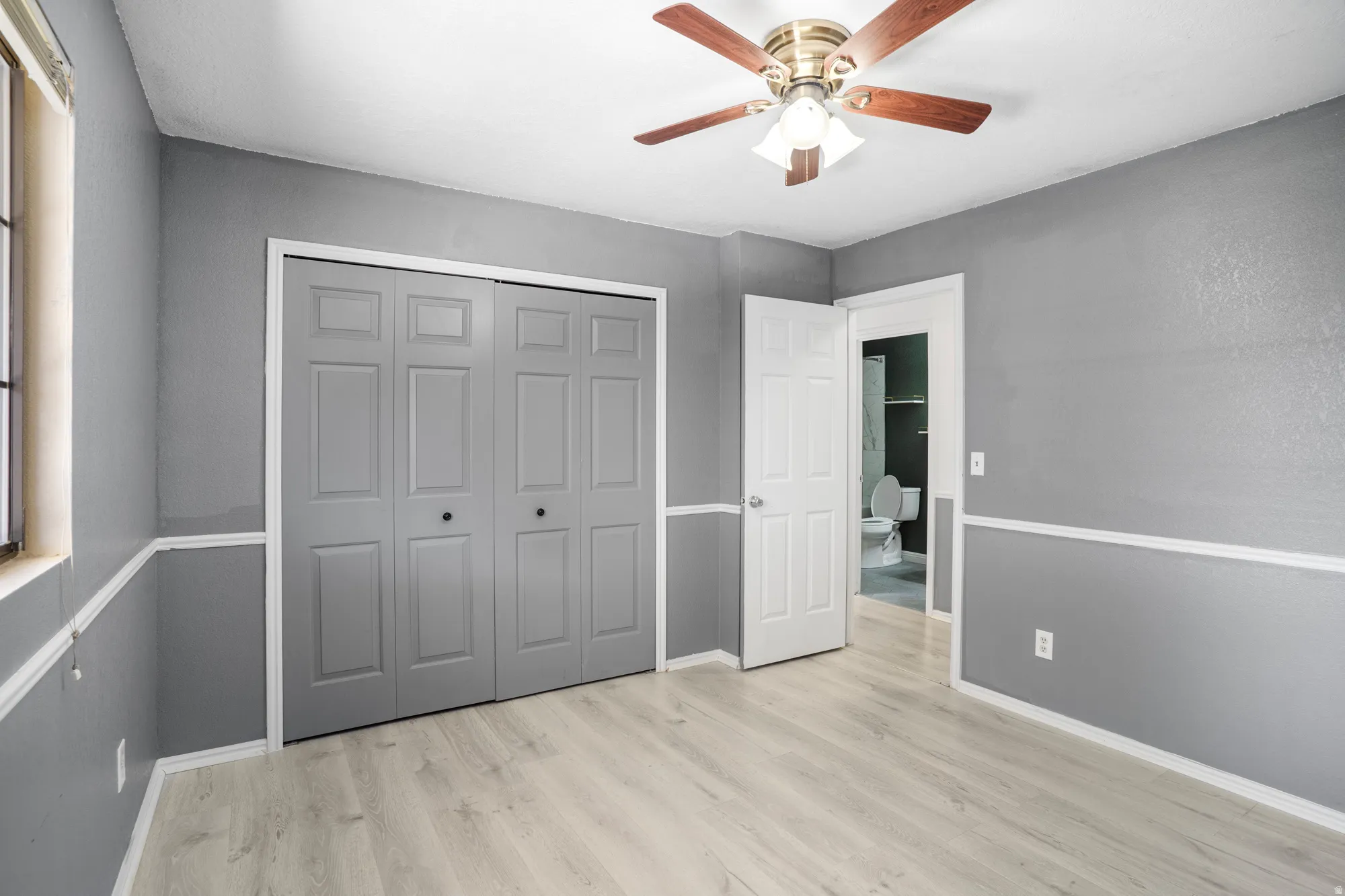 Unfurnished bedroom featuring ceiling fan, light wood-type flooring, and a closet