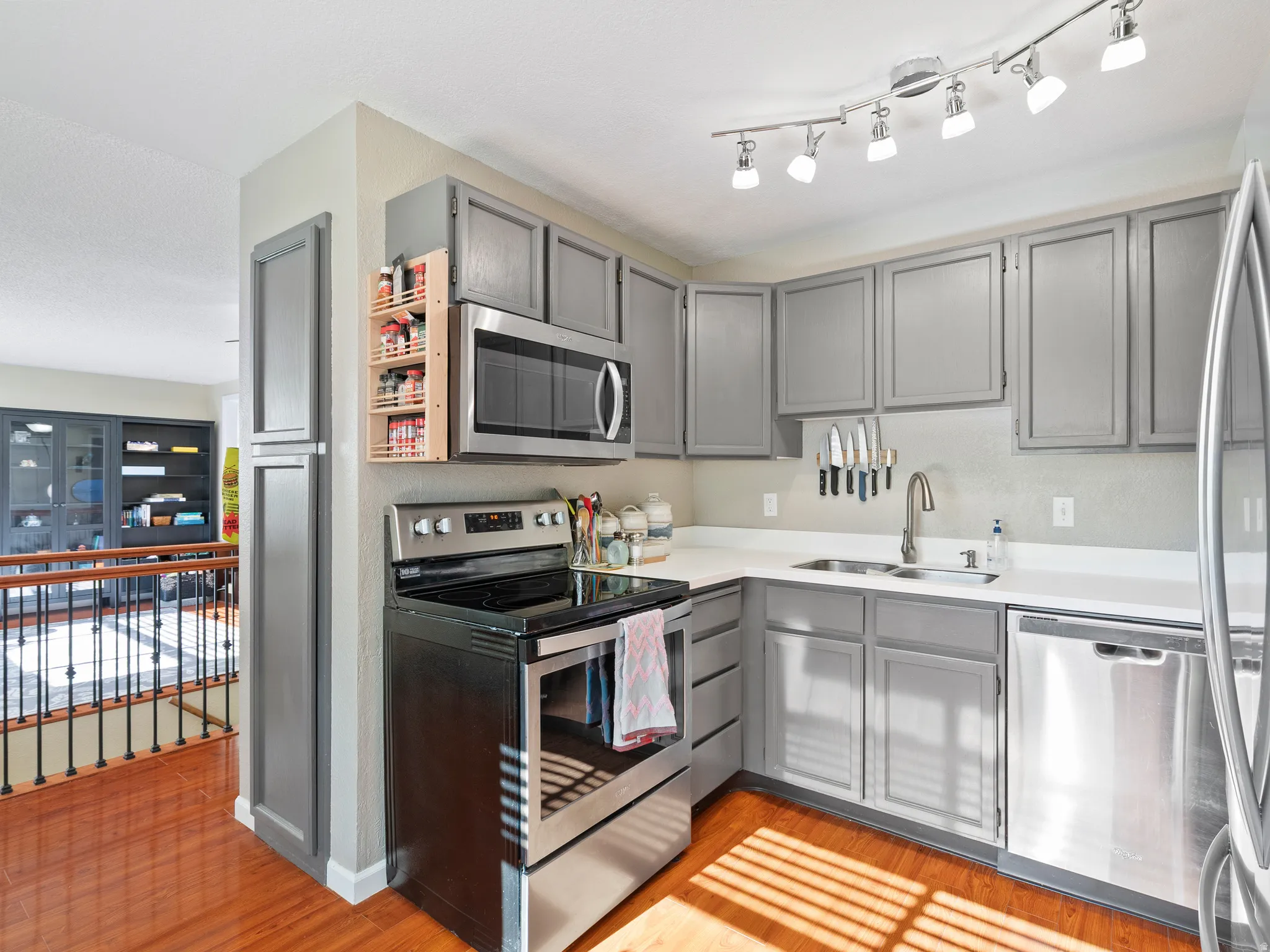 Kitchen featuring gray cabinetry, stainless steel appliances, light countertops, and light wood finished floors