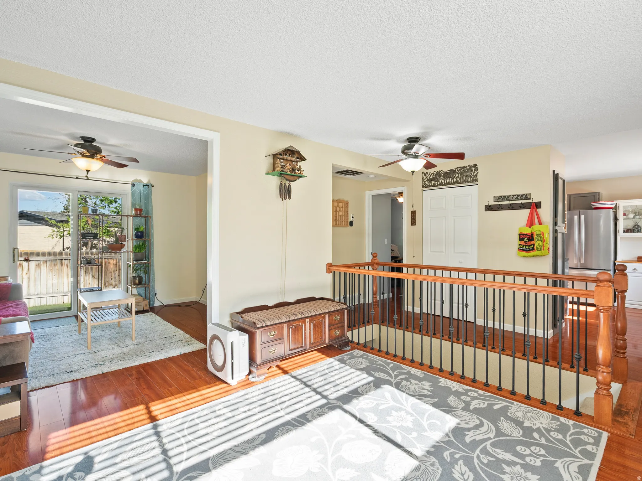Hallway with wood-type flooring, a textured ceiling, and an upstairs landing