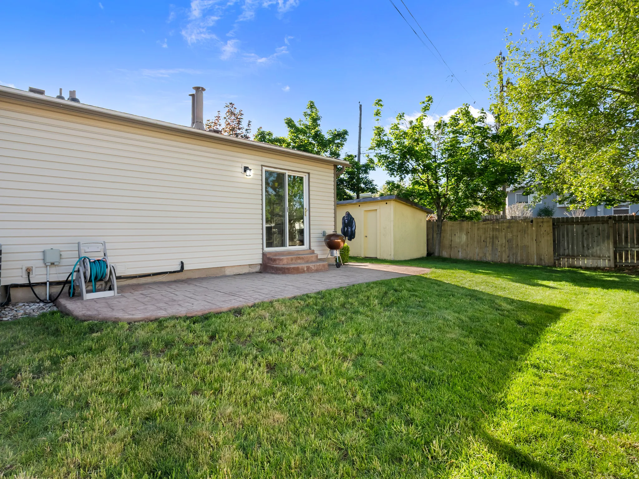 Back of property with a patio area, a fenced backyard, an outbuilding, and entry steps