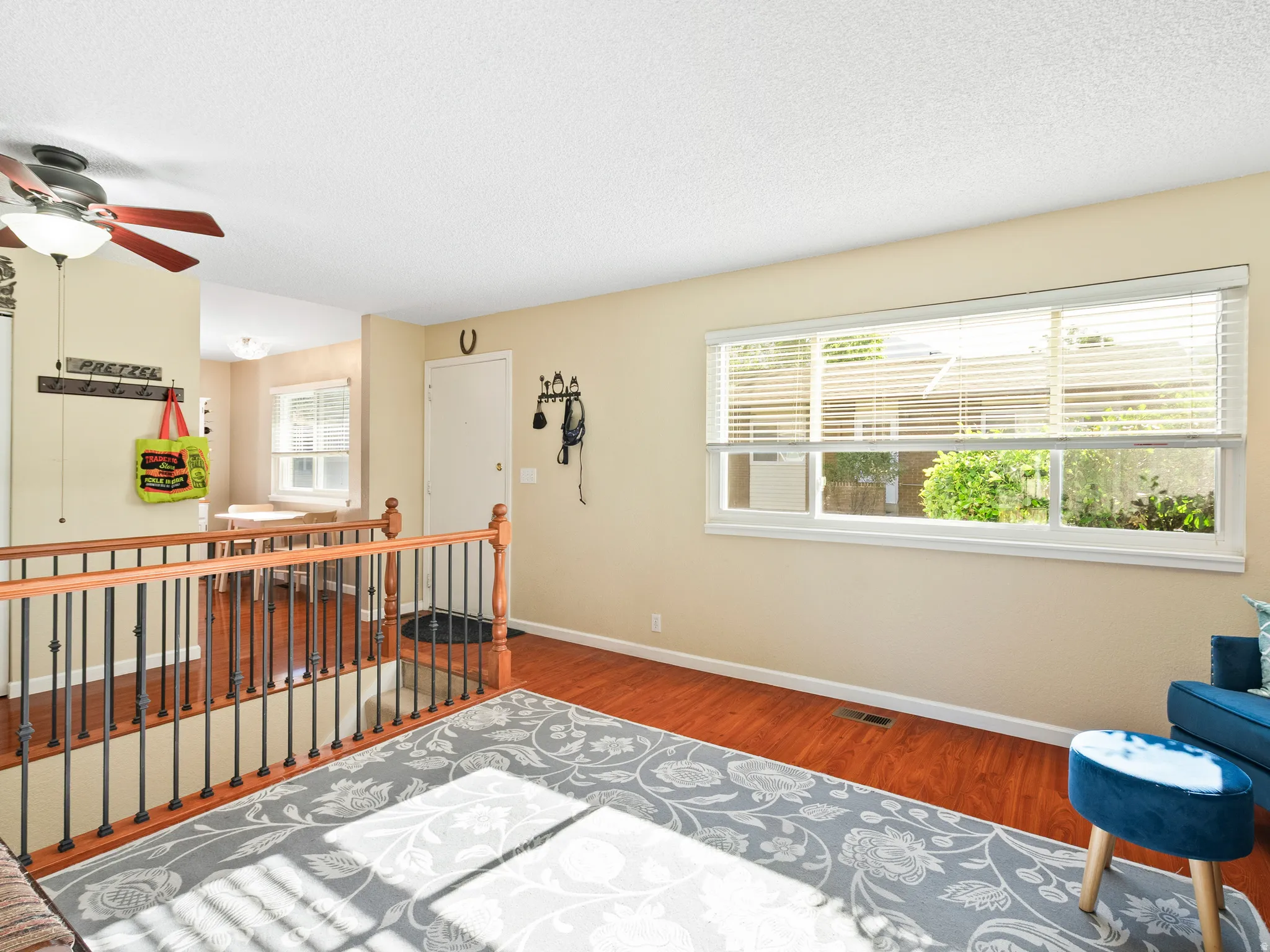 Sitting room featuring wood finished floors, a ceiling fan, a textured ceiling, and an upstairs landing