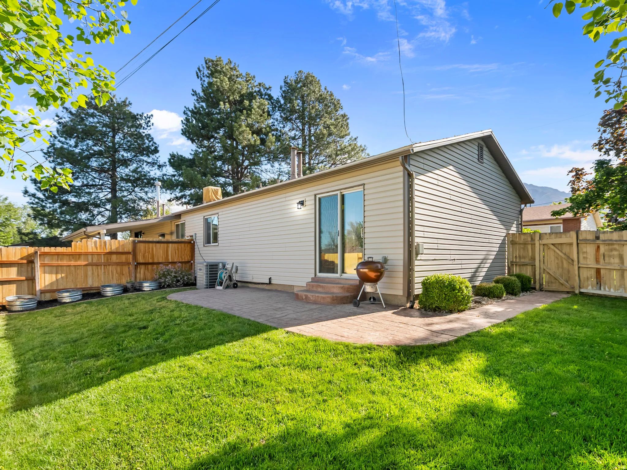 Rear view of house featuring a gate, a fenced backyard, entry steps, and a patio area