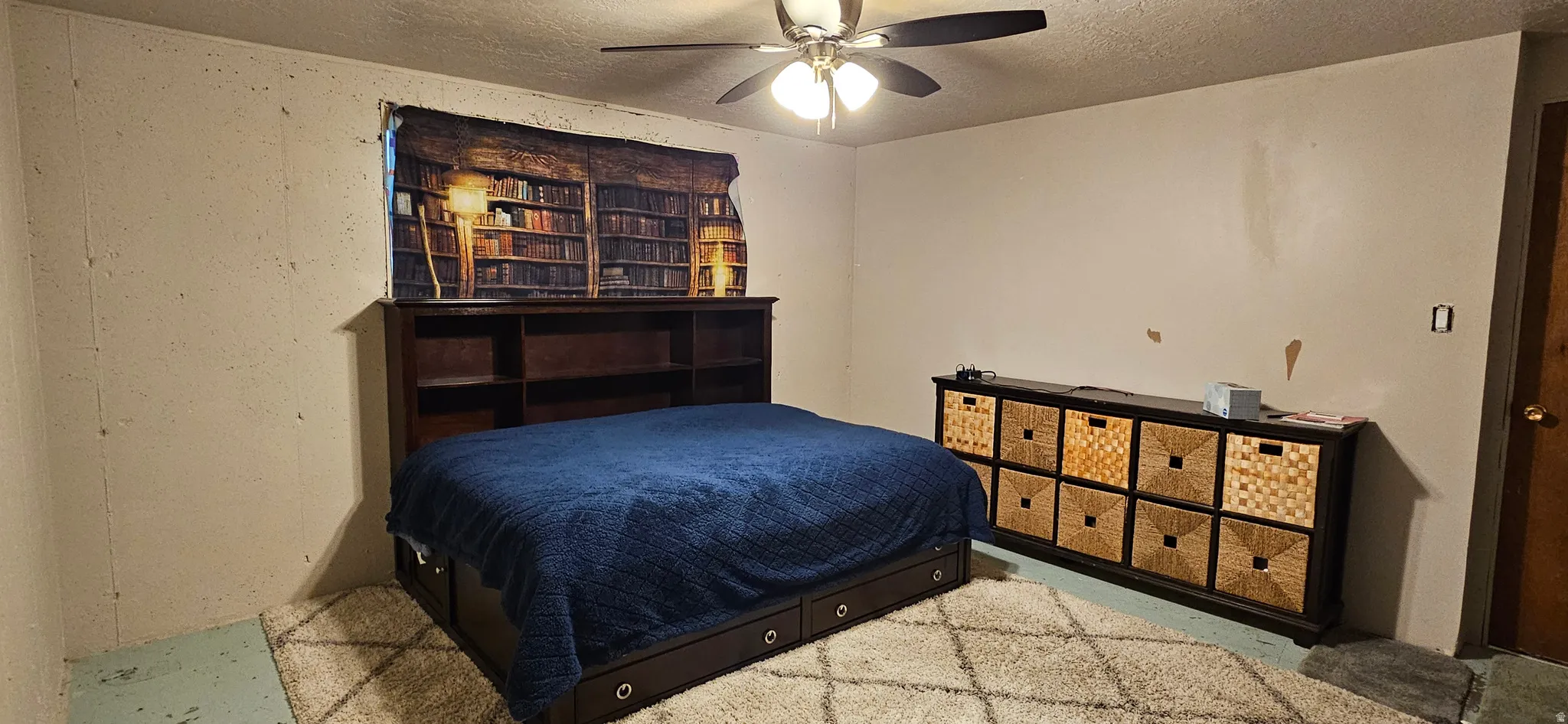 Bedroom with a ceiling fan and a textured ceiling