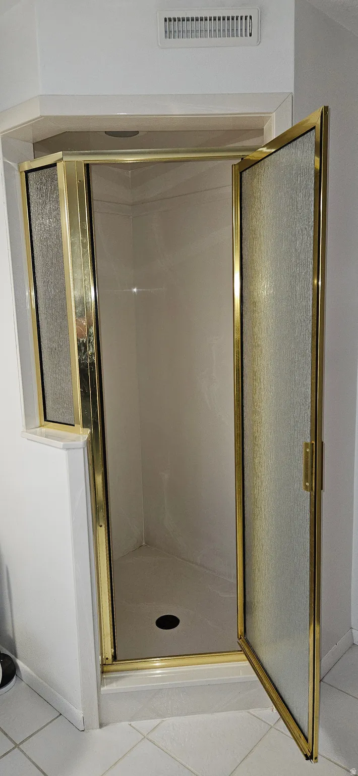 Bathroom with light tile patterned floors and a stall shower
