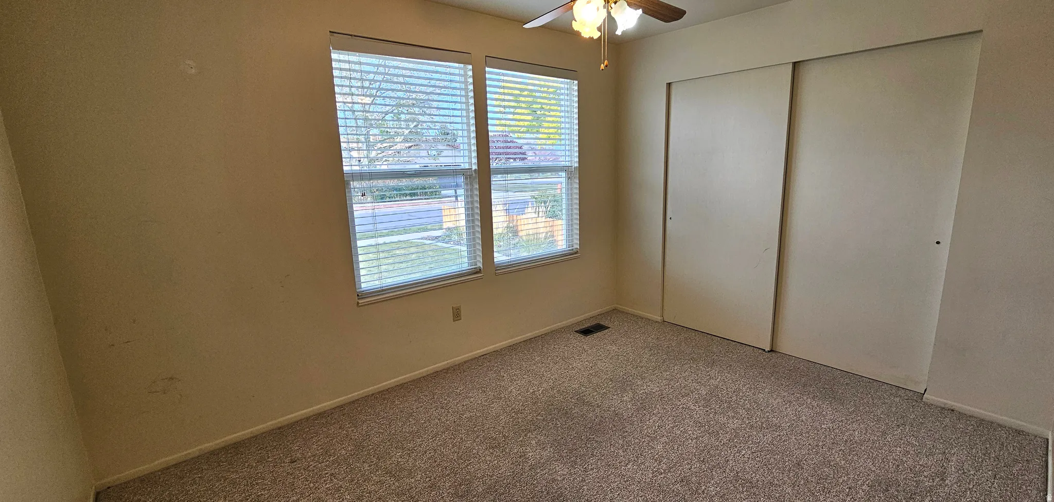 Unfurnished bedroom featuring carpet flooring, a closet, and a ceiling fan