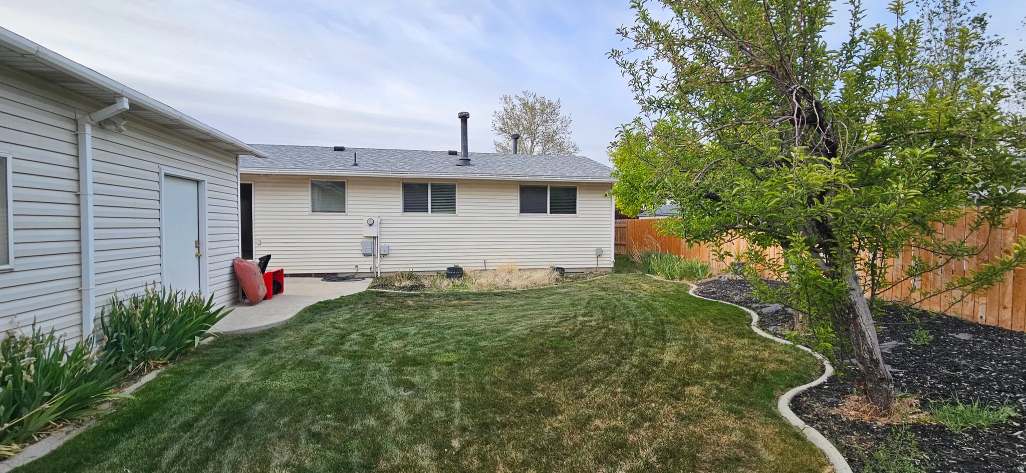 Rear view of house with a patio area, a fenced backyard, and a shingled roof