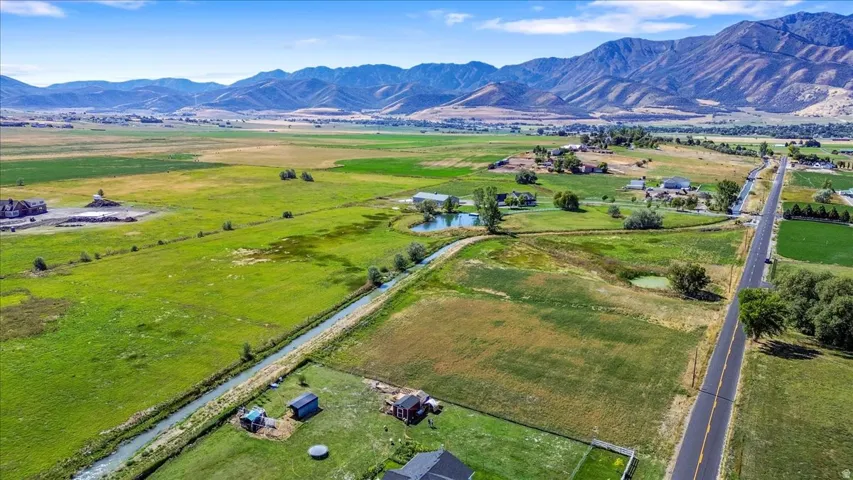 Aerial view of sparsely populated area with a water and mountain view and agricultural land