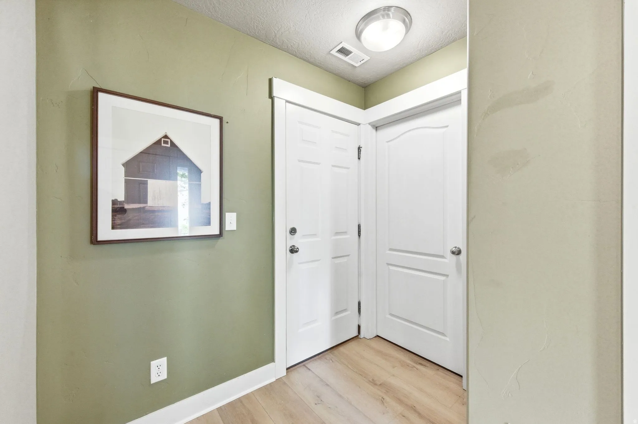 Entrance foyer with light wood finished floors and a textured ceiling