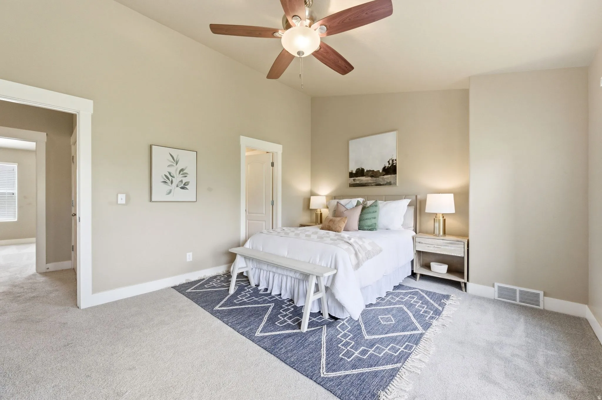 Bedroom featuring light carpet, vaulted ceiling, and ceiling fan