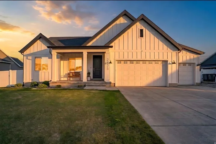 Contemporary farmhouse-style exterior with vertical white siding and dark trim accents
