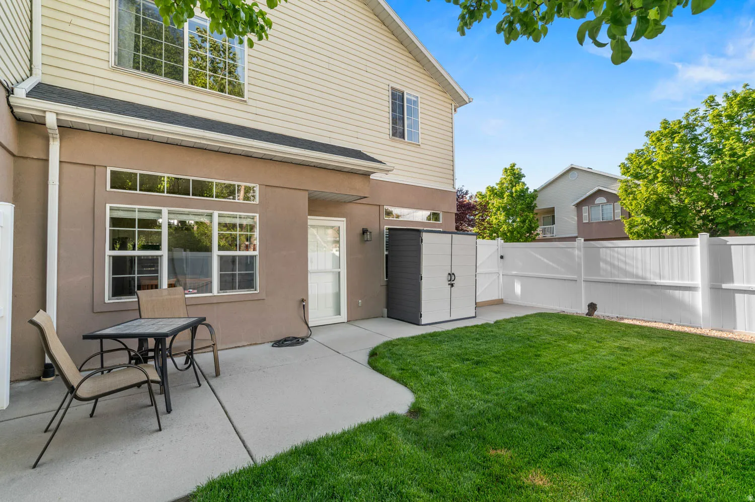 Back of property featuring a fenced backyard, a patio area, a gate, a shingled roof, and stucco siding