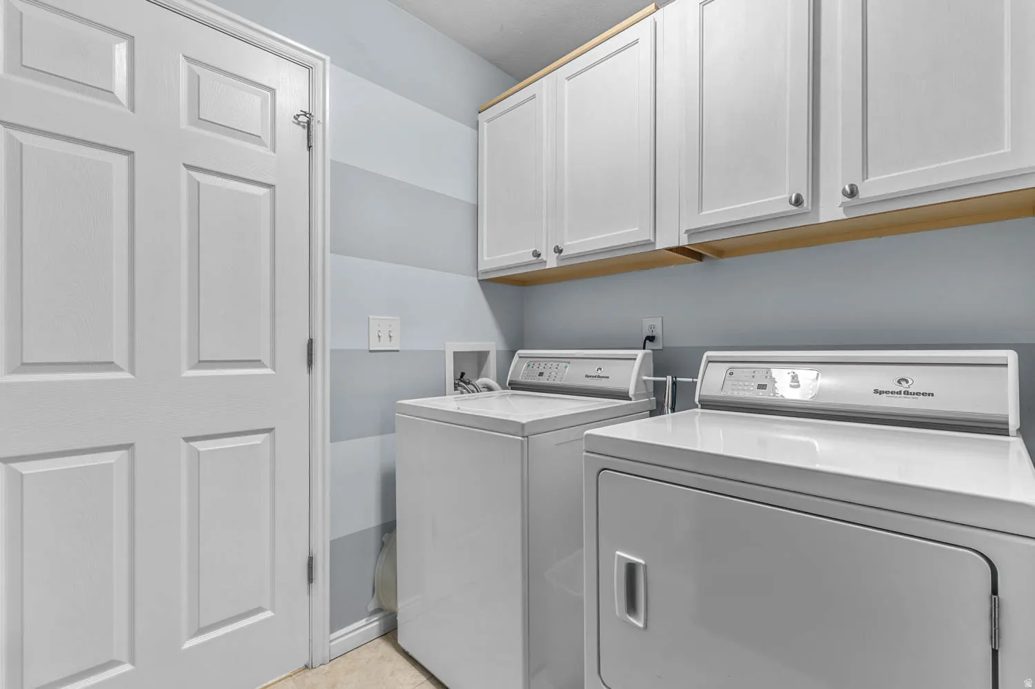 Laundry area featuring separate washer and dryer and cabinet space