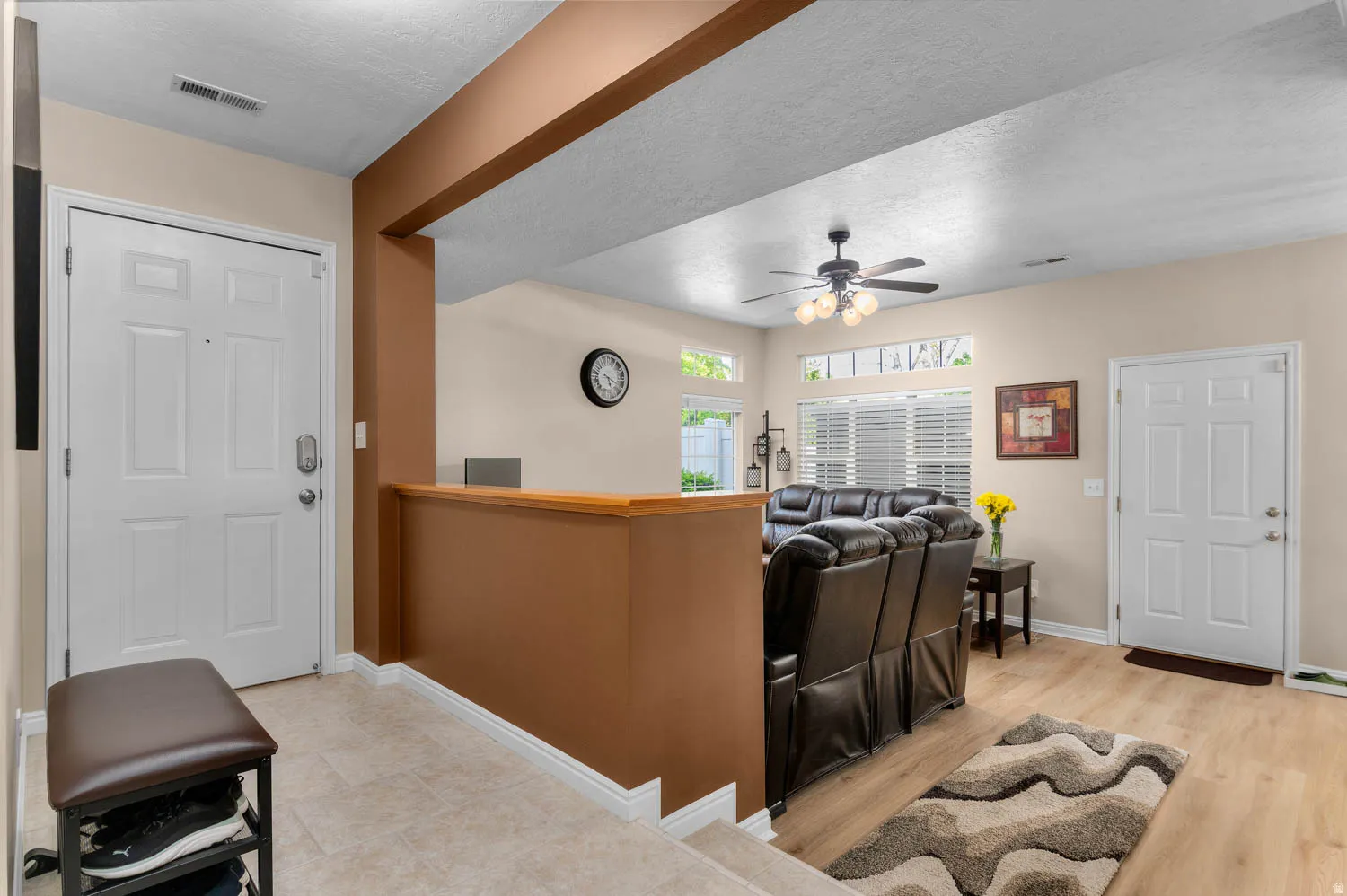 Living area featuring a textured ceiling, a ceiling fan, and light wood finished floors