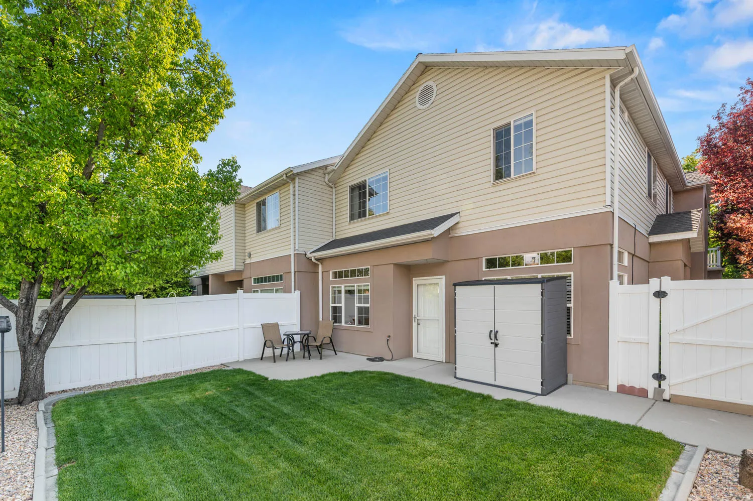 Rear view of property featuring a fenced backyard, a patio area, a gate, and stucco siding