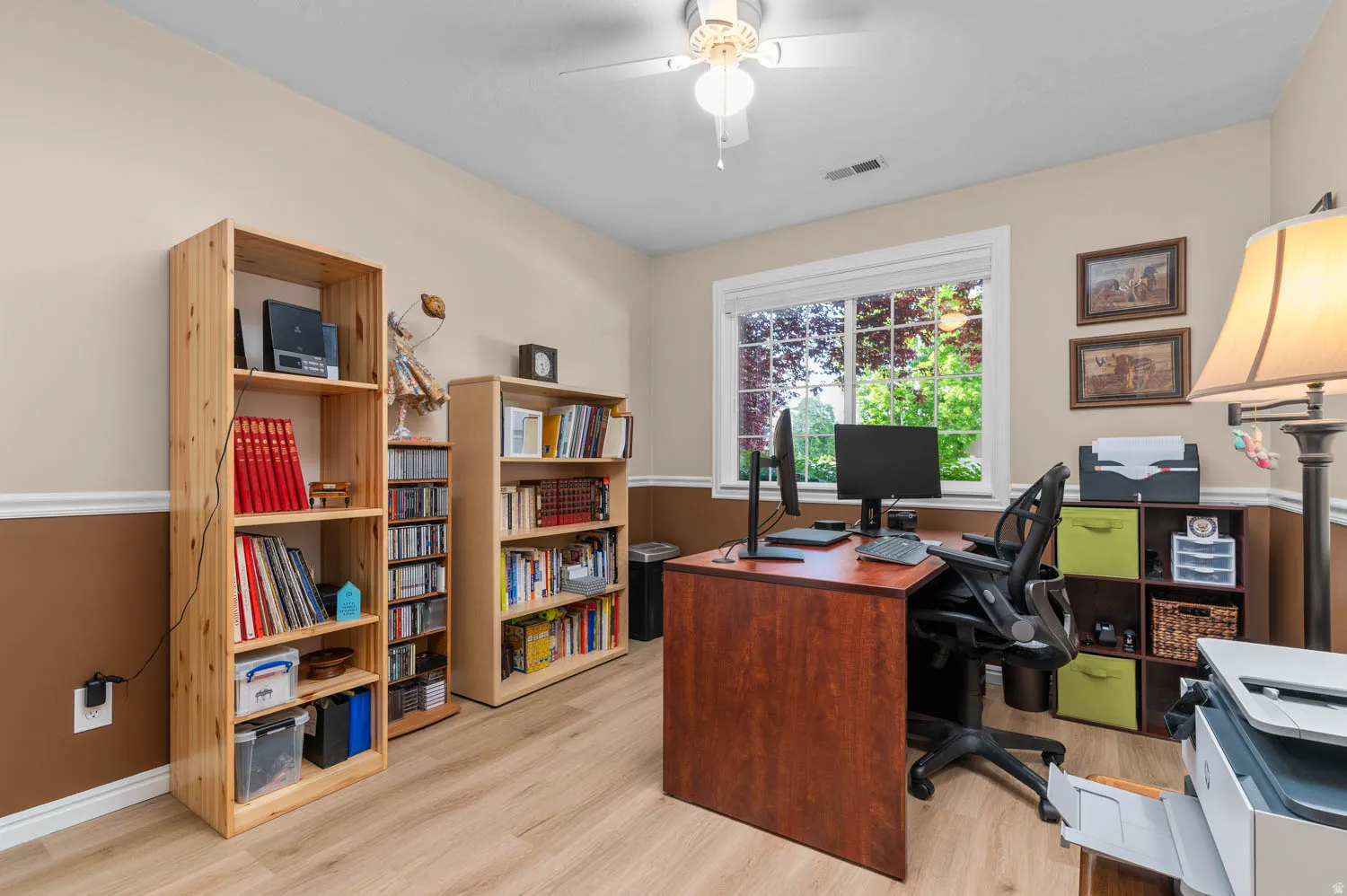 Office space with light wood finished floors and a ceiling fan