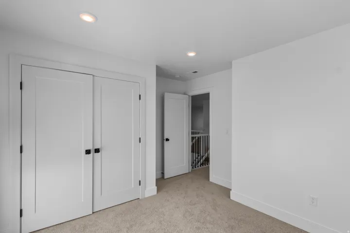 Unfurnished bedroom with light colored carpet, a closet, and recessed lighting
