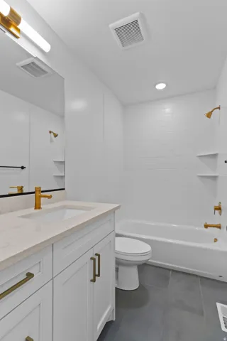 Full bath with vanity, tub / shower combination, and dark tile patterned floors