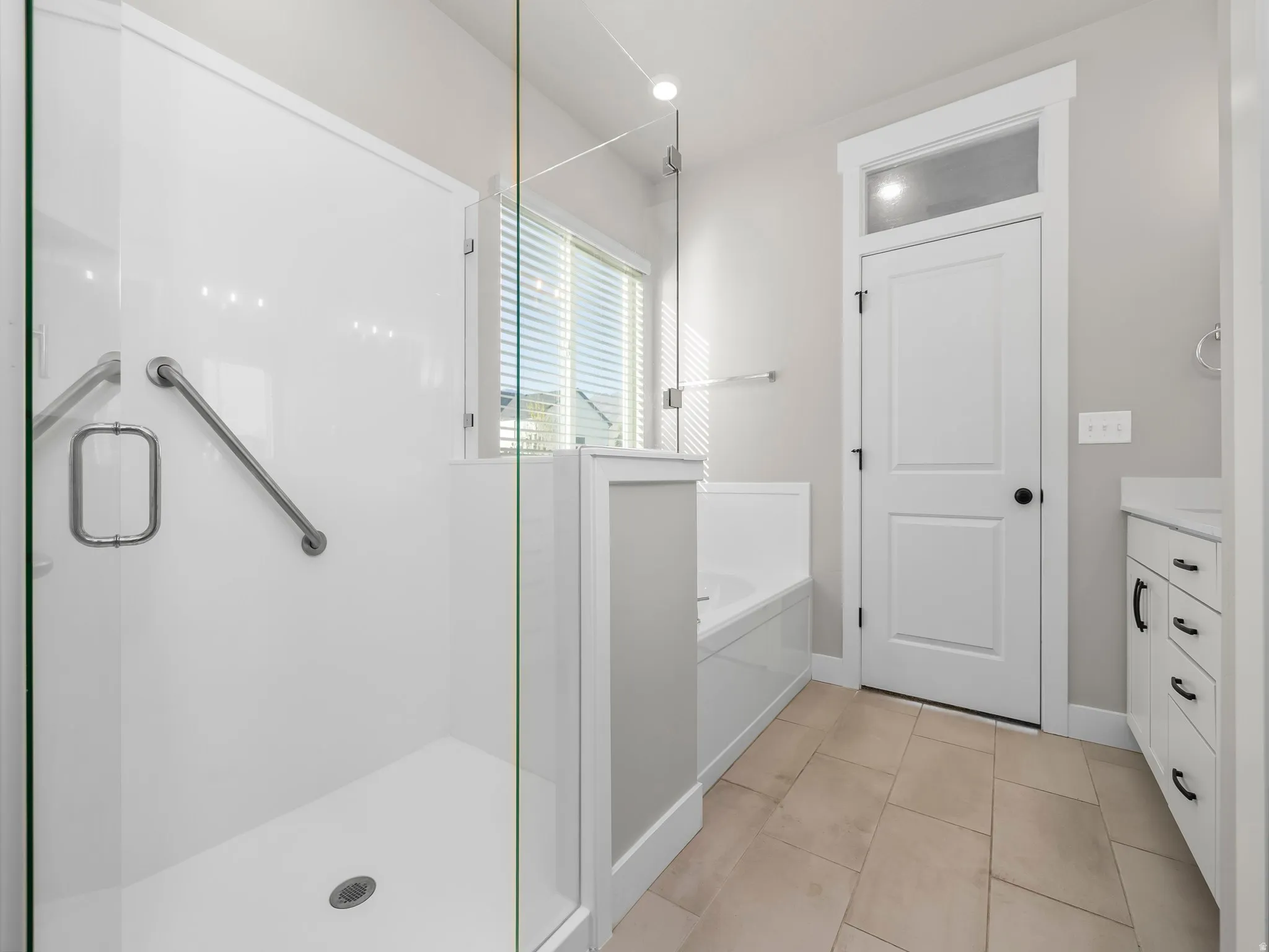 Bathroom with a garden tub, vanity, a stall shower, light tile patterned floors, and recessed lighting
