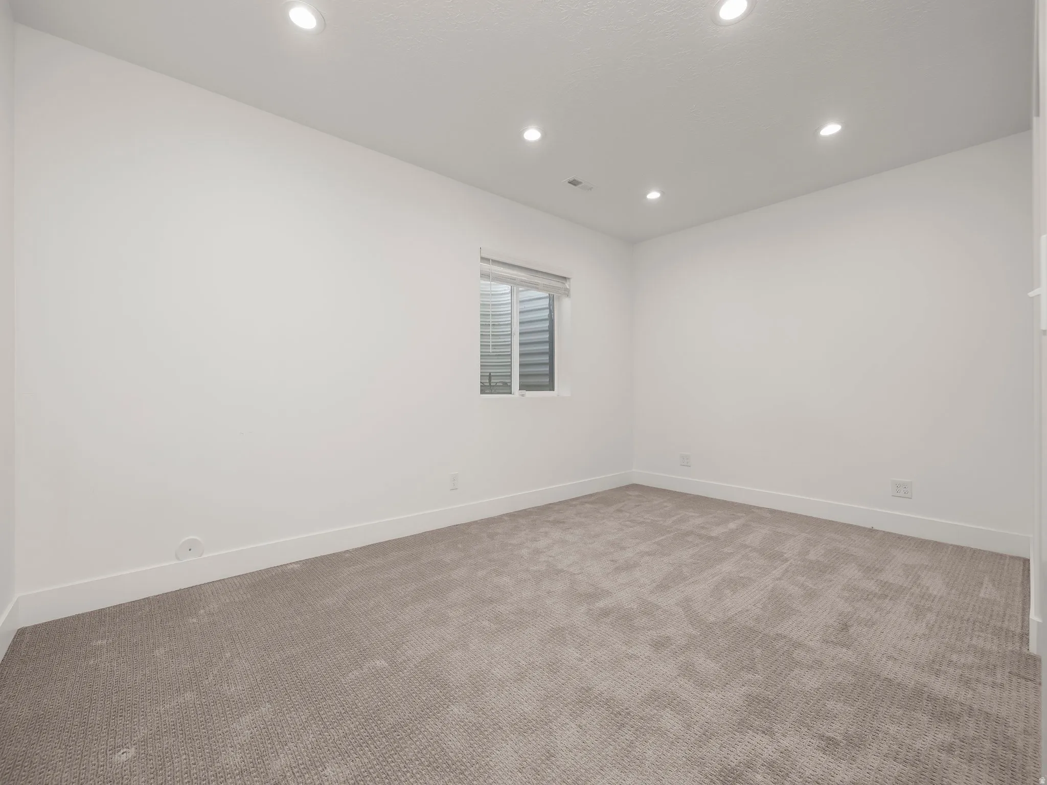 Empty room with recessed lighting and carpet floors