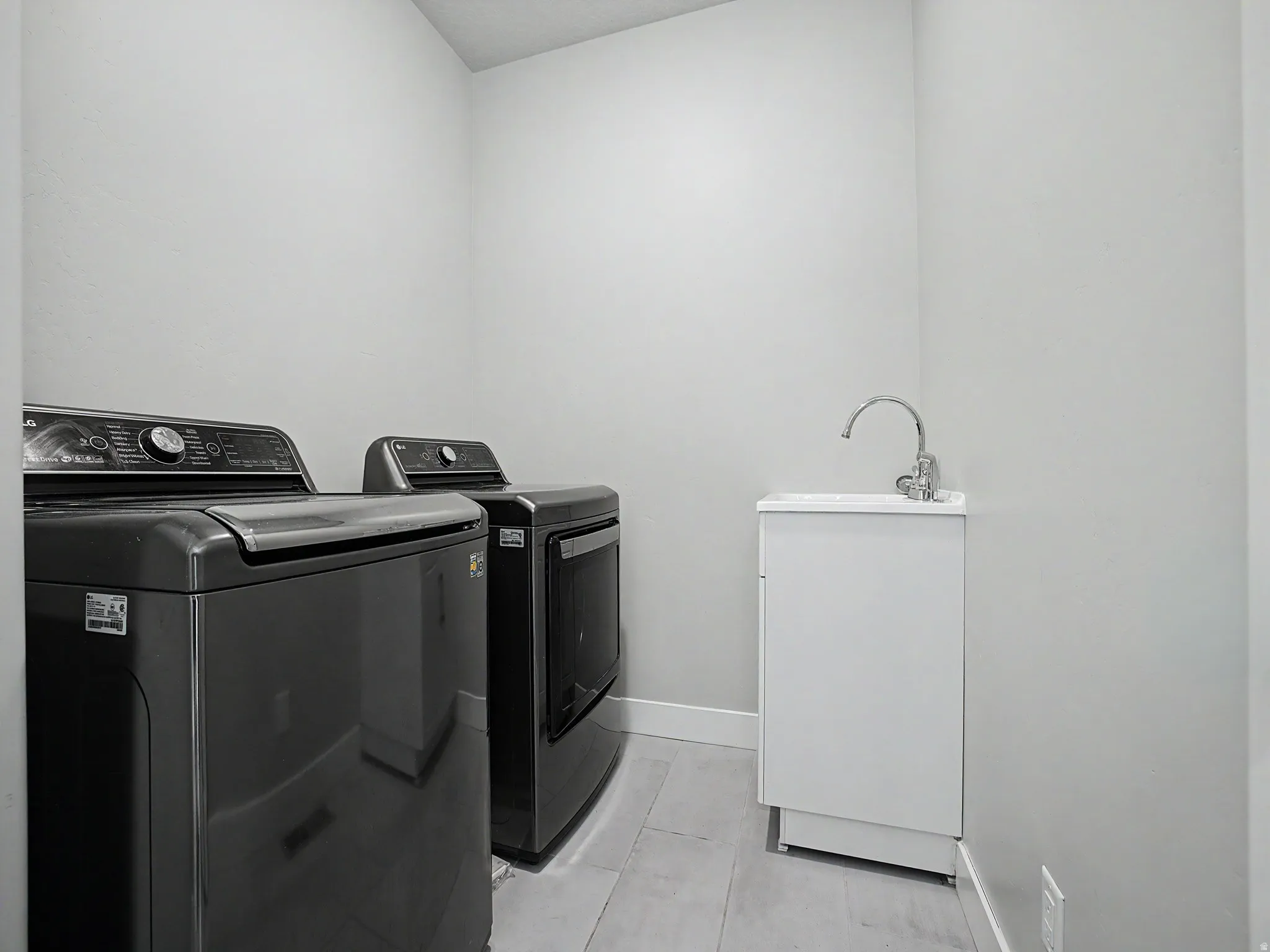 Laundry area featuring washer and dryer and light tile patterned floors