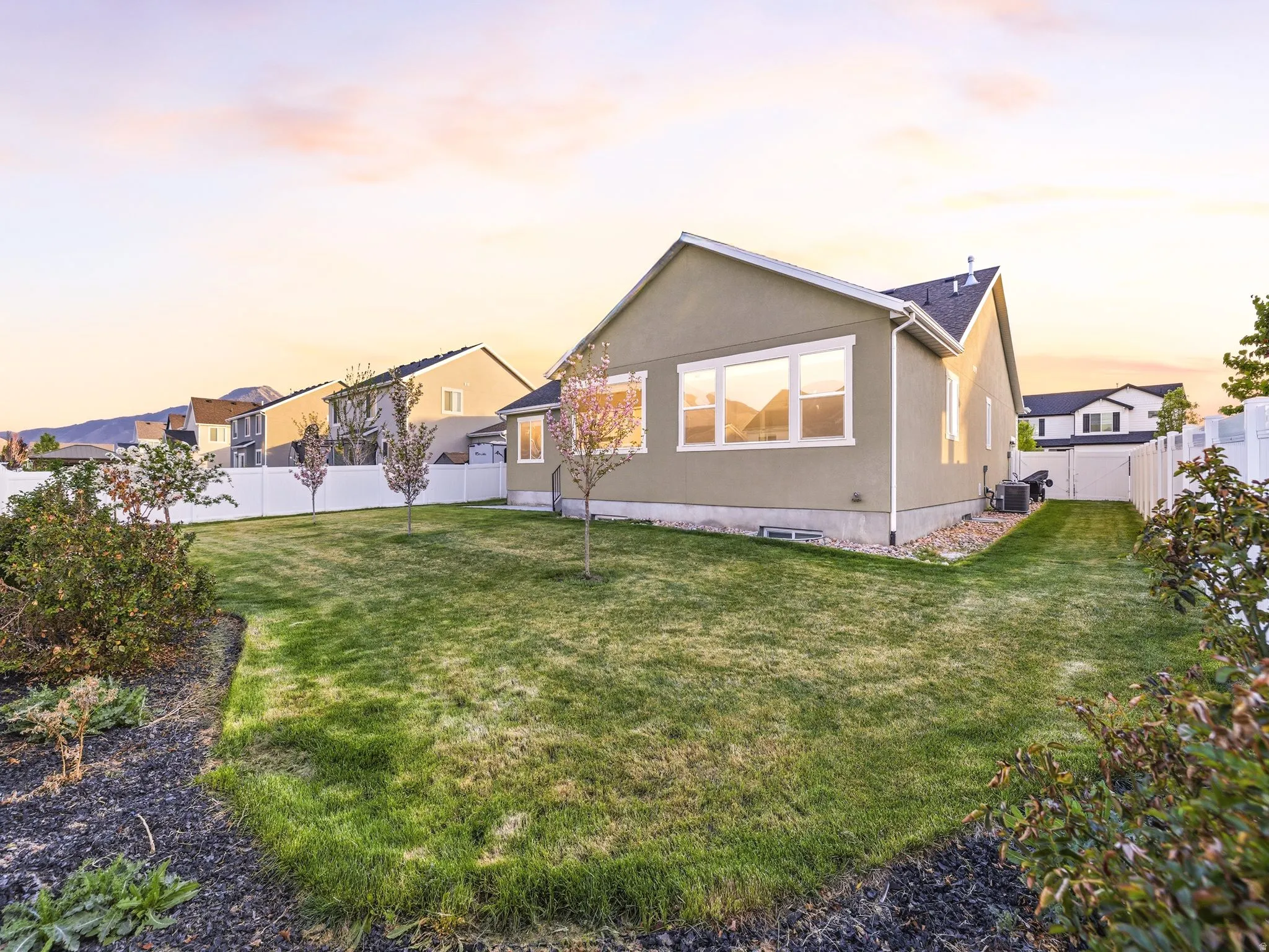 Rear view of property featuring a fenced backyard and stucco siding