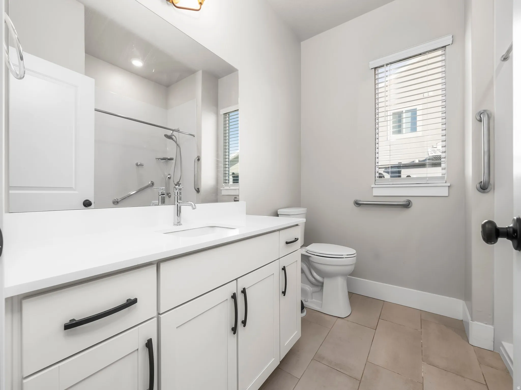 Full bath featuring vanity, a shower, and light tile patterned flooring