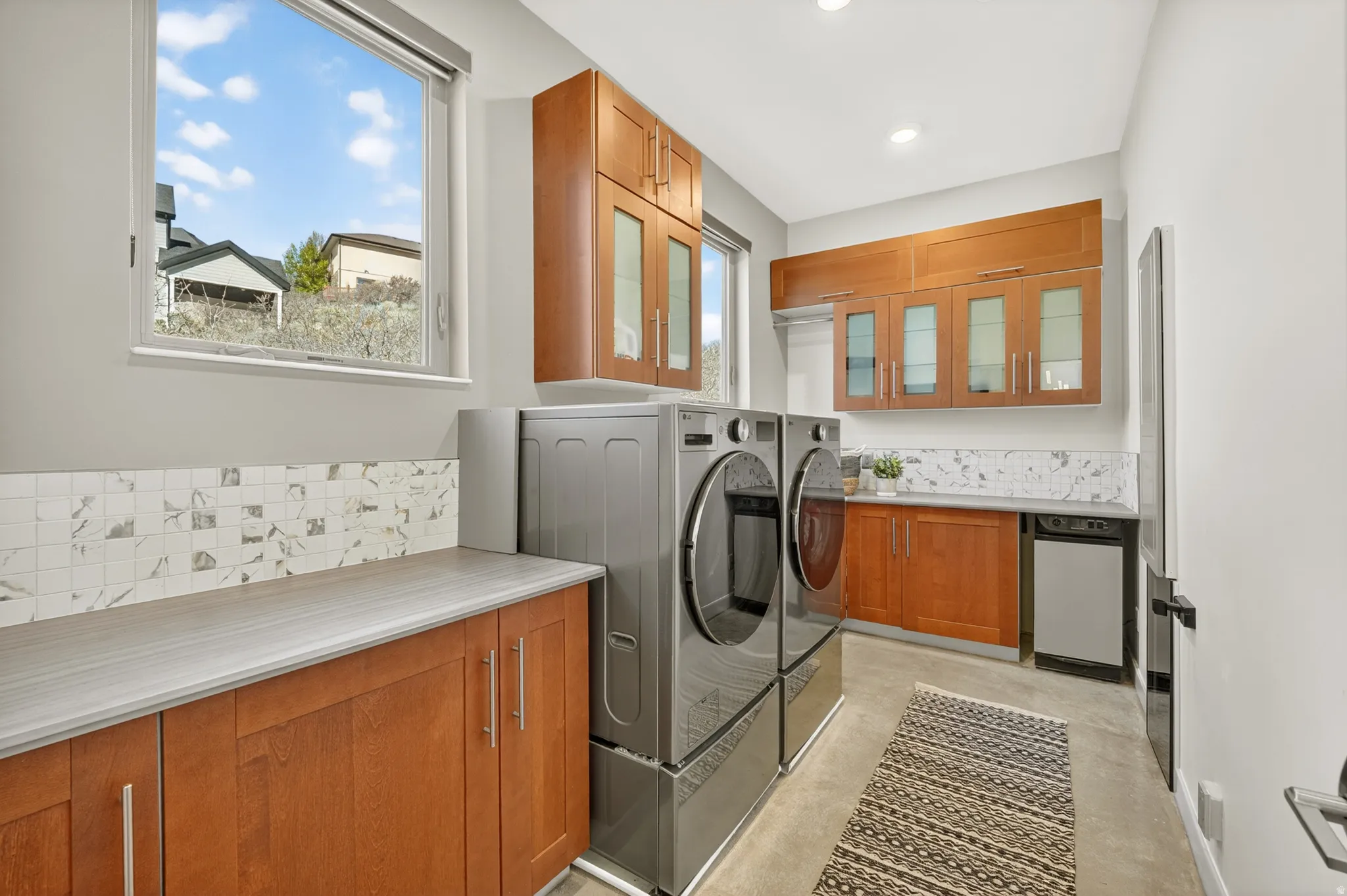 Main Floor Laundry area featuring washer and dryer and cabinet space