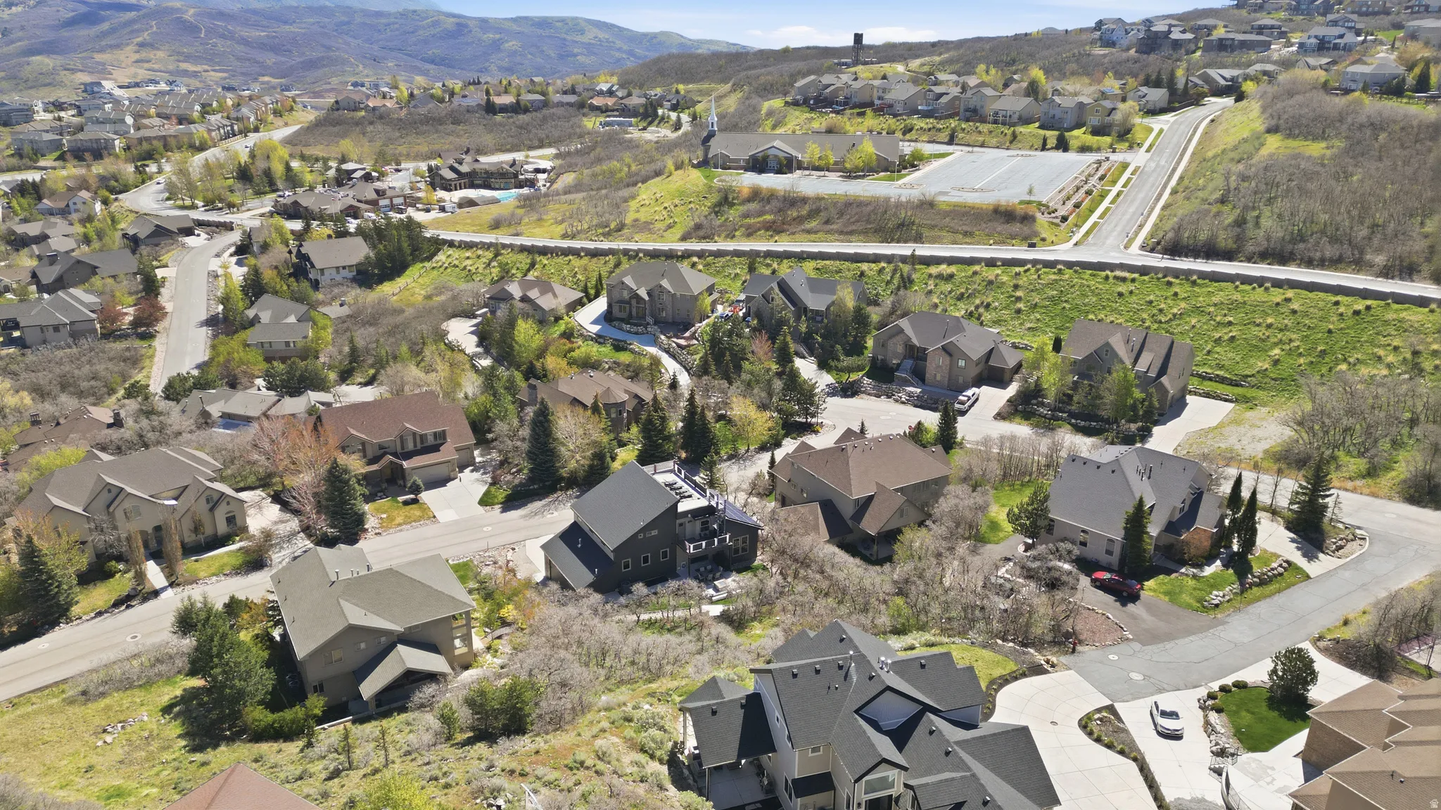 Aerial view of property and surrounding area with nearby suburban area and a mountainous background