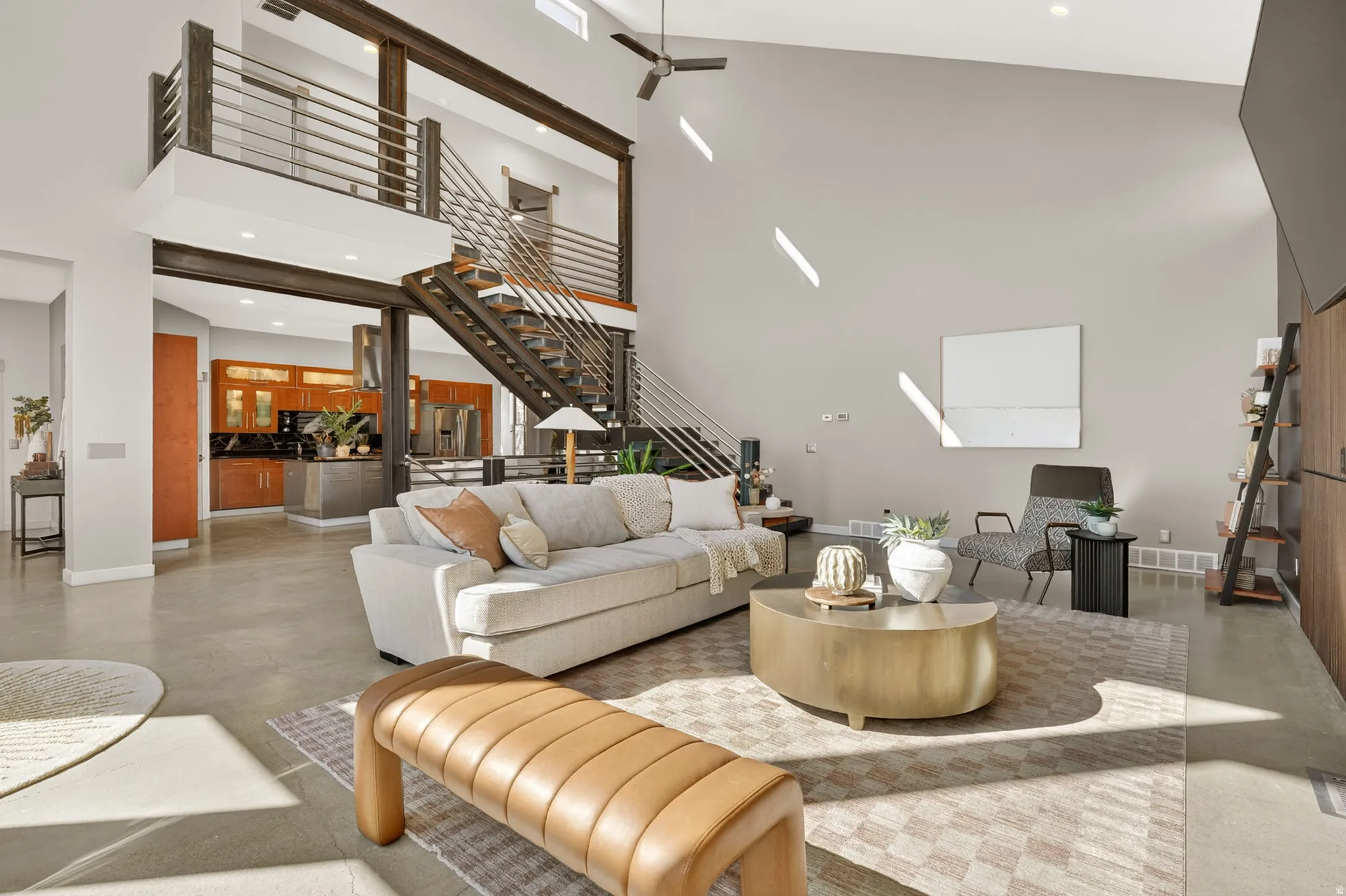 Living area with a glass covered fireplace, recessed lighting, concrete floors, healthy amount of natural light, and vaulted ceiling