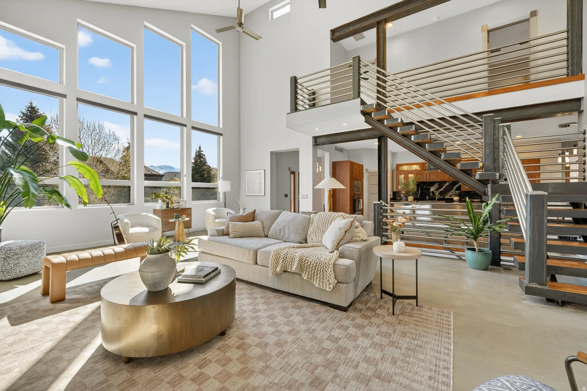 Living area with a glass covered fireplace, recessed lighting, concrete floors, healthy amount of natural light, and vaulted ceiling
