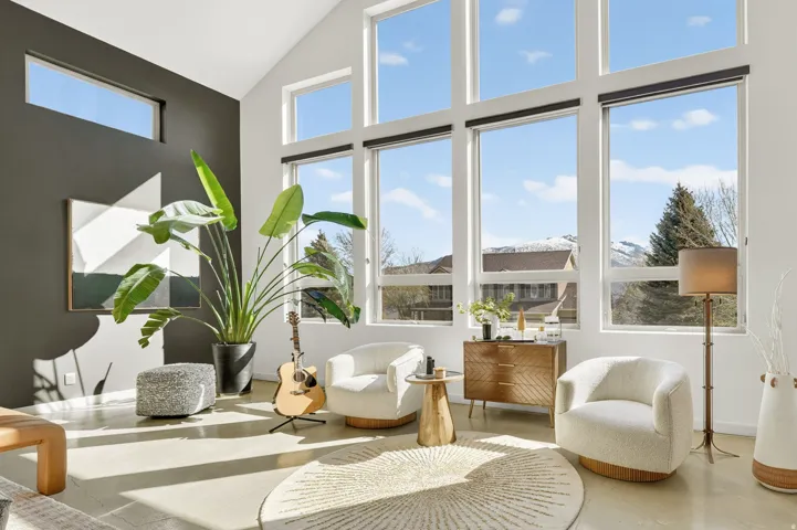 Living area with a glass covered fireplace, recessed lighting, concrete floors, healthy amount of natural light, and vaulted ceiling