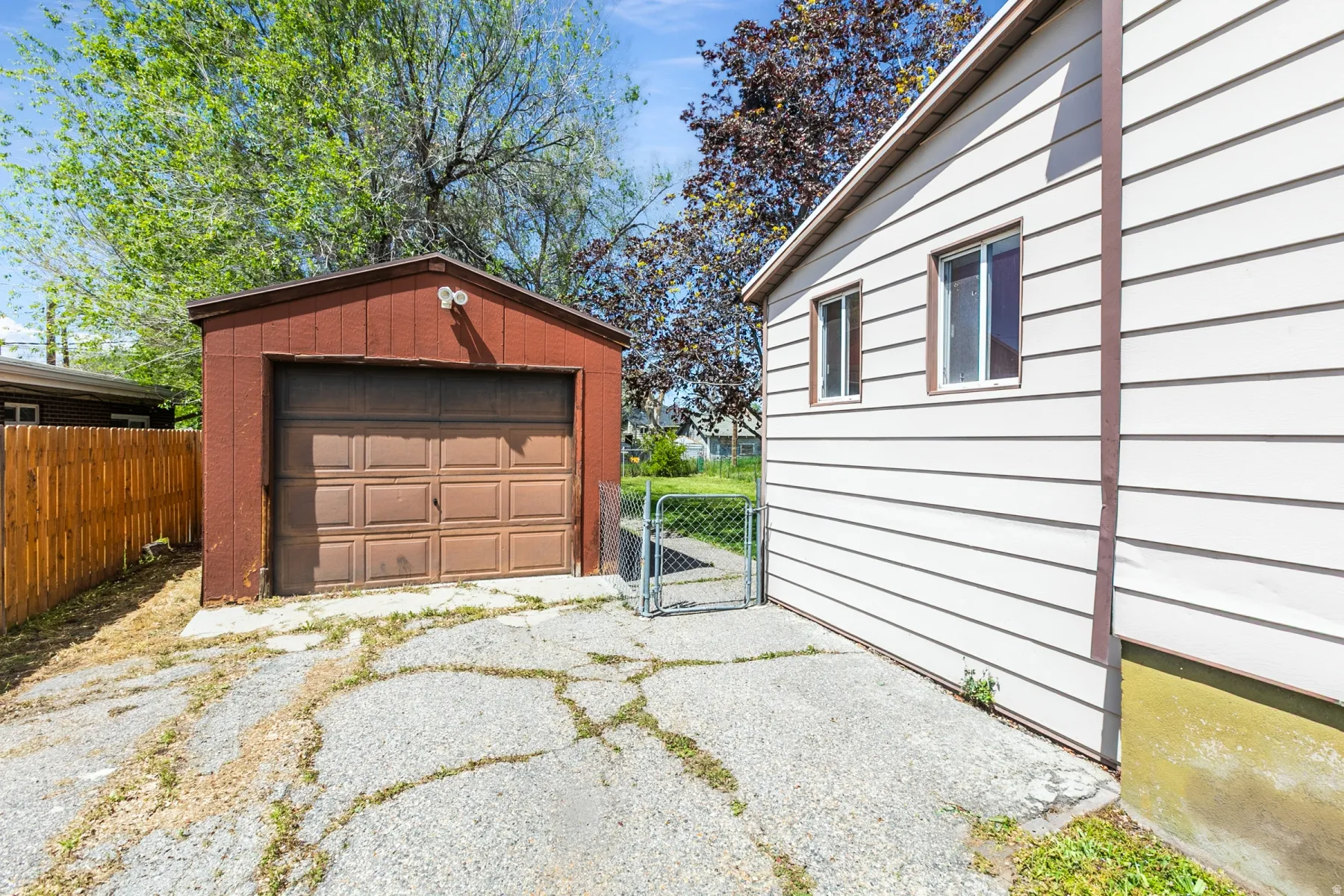 Detached garage with a gate and asphalt driveway