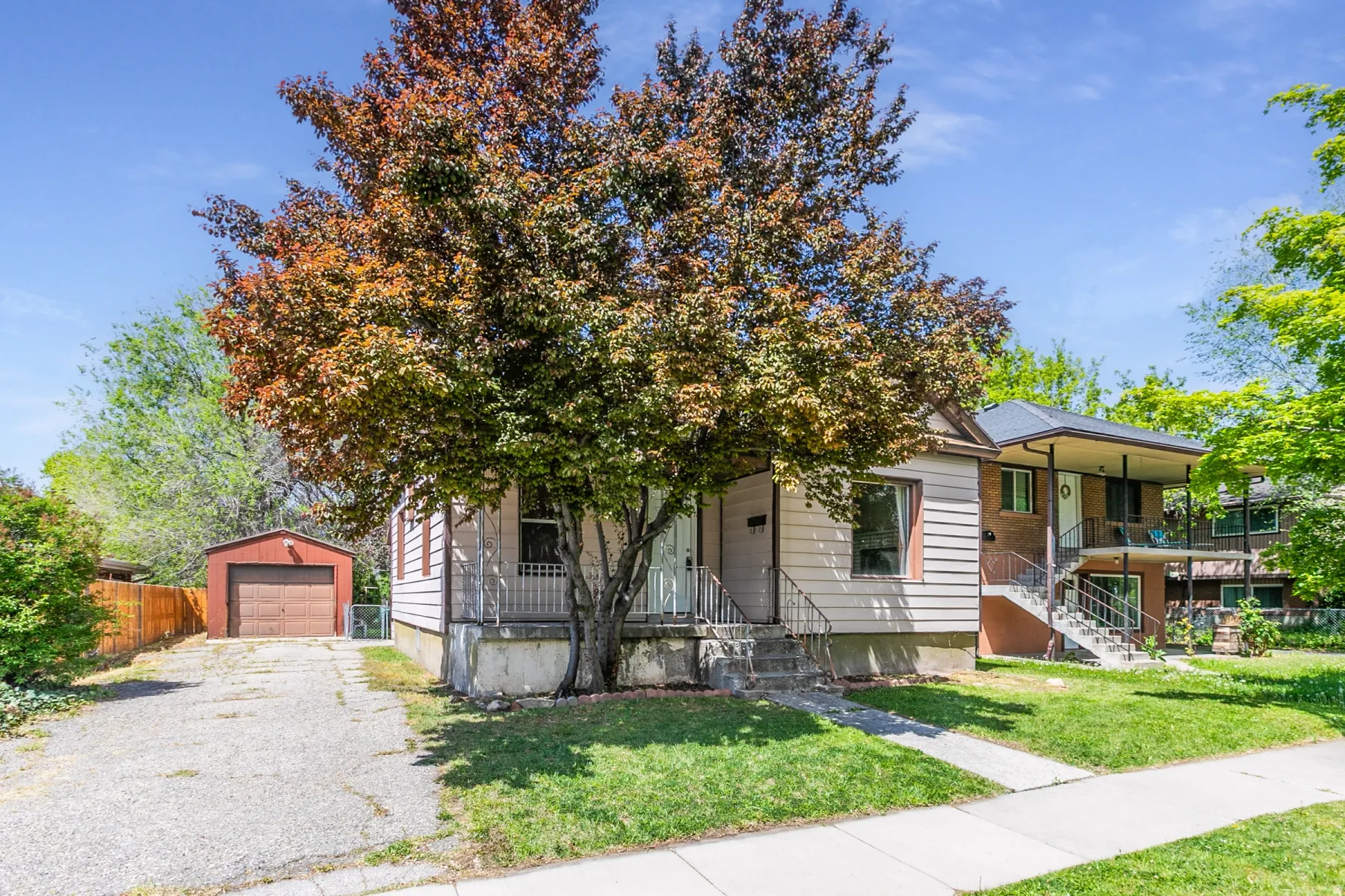 View of front of home with an outbuilding, a garage, driveway, and covered porch