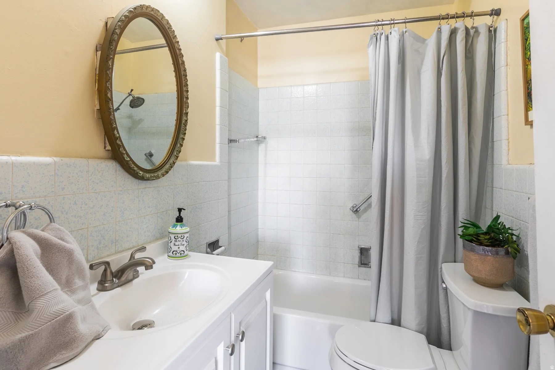 Bathroom with vanity, tile walls, and shower / bath combination with curtain
