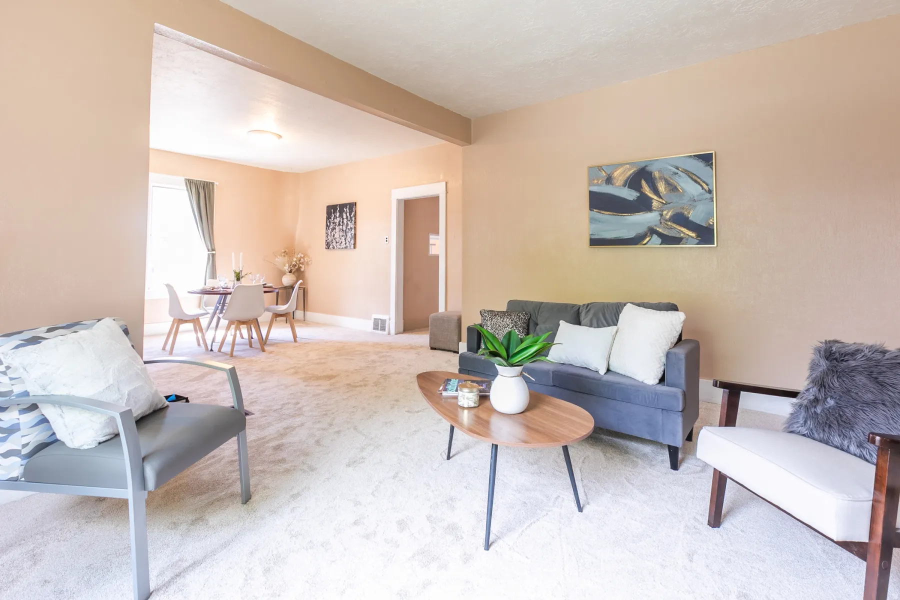 Carpeted living area with baseboards and beamed ceiling