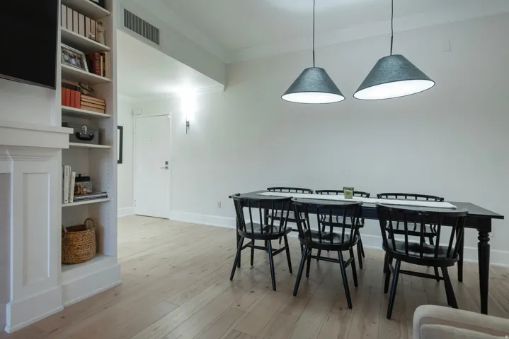 Dining space with crown molding and light wood-style flooring