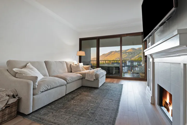 Living area featuring a tile fireplace, light wood-style floors, and crown molding