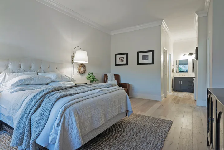Bedroom featuring light wood finished floors, crown molding, and washer / dryer