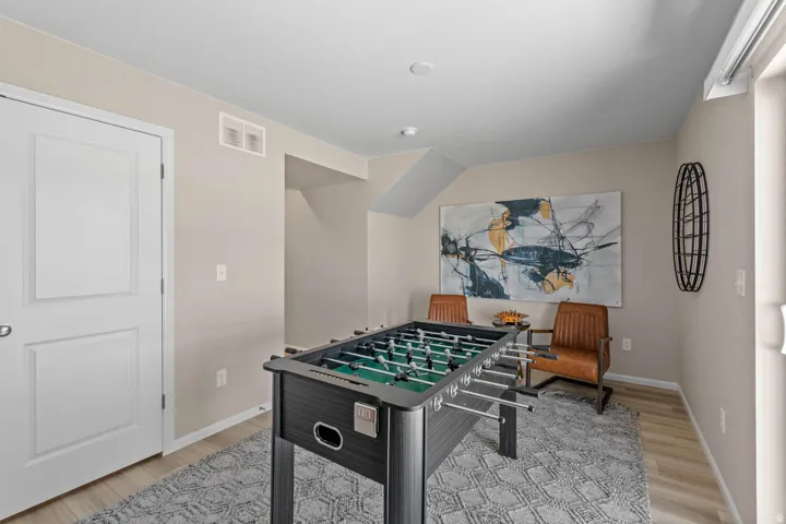 Game room with light wood-style flooring and baseboards