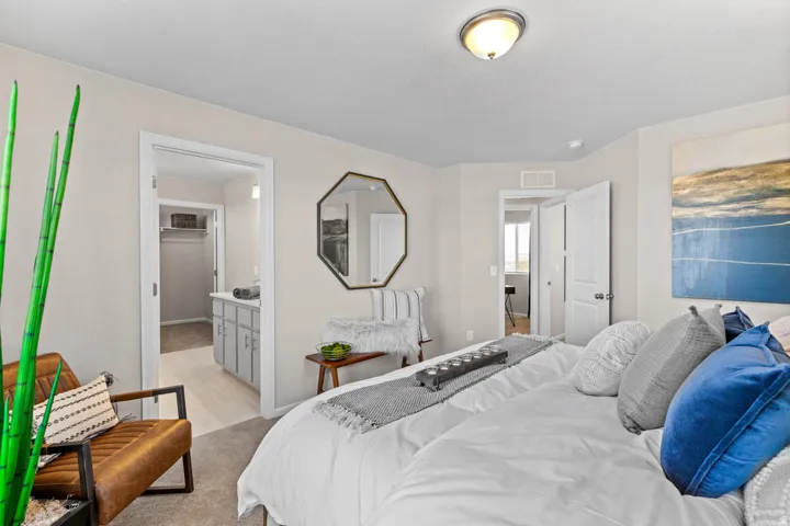 Bedroom featuring ensuite bath and light carpet