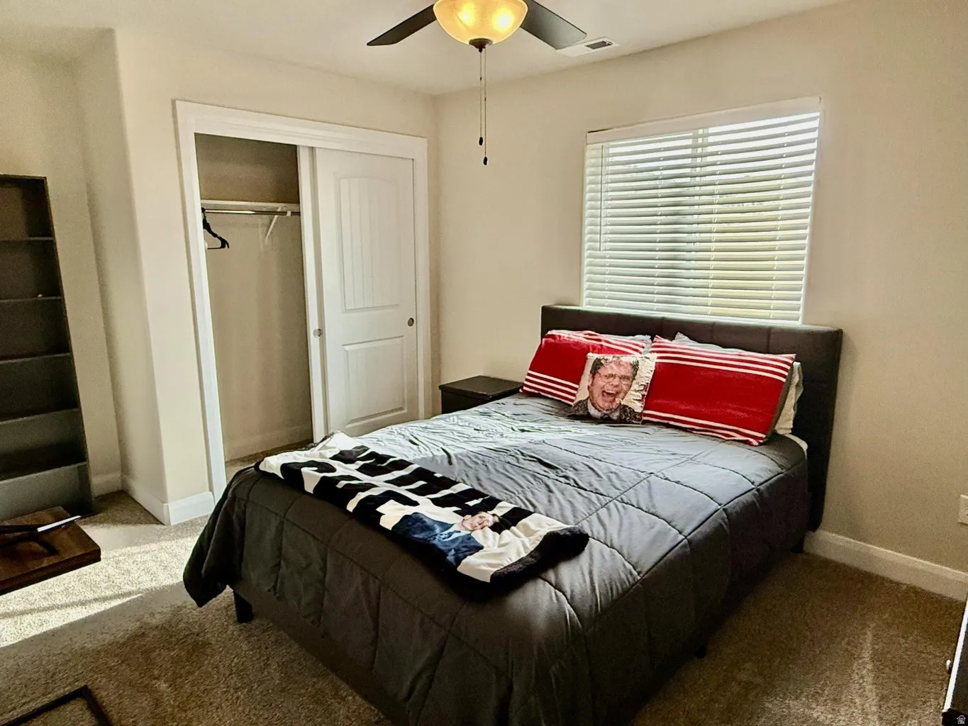 Carpeted bedroom featuring a closet and ceiling fan