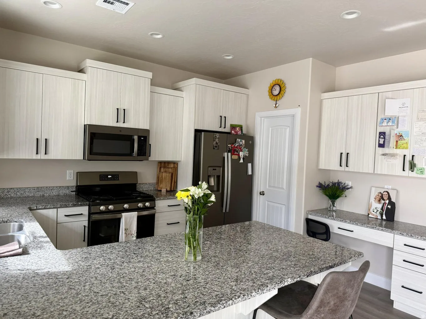 Kitchen with dark stone countertops, stainless steel appliances, a breakfast bar, a peninsula, and recessed lighting