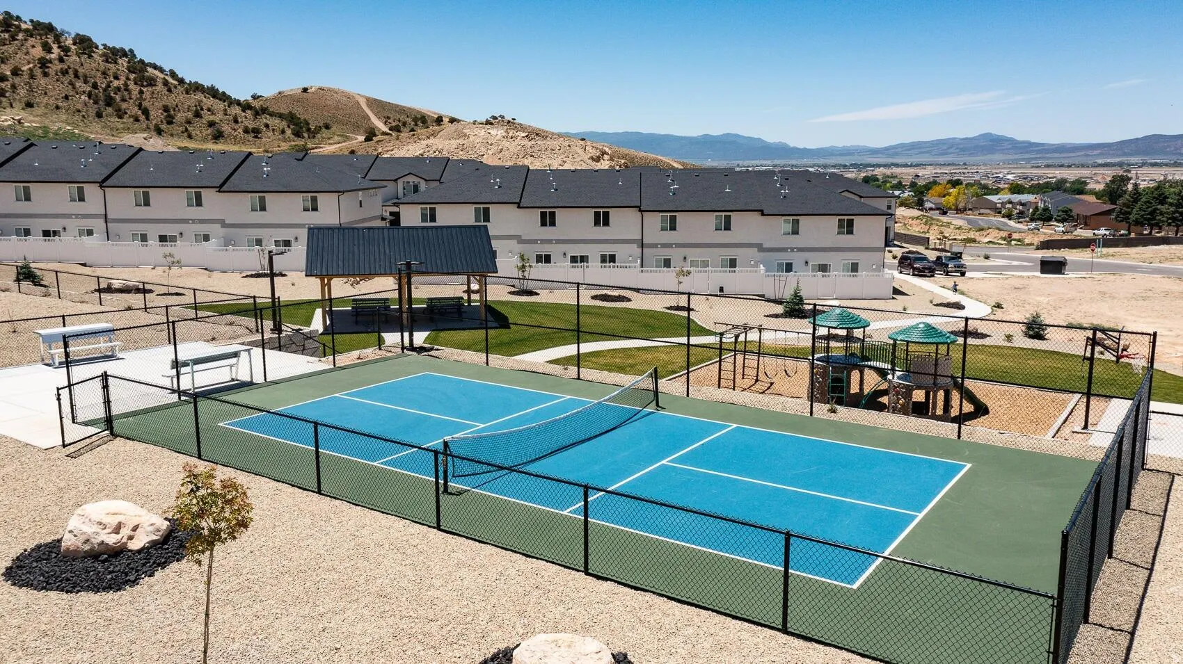 View of tennis court with a mountain view and a residential view