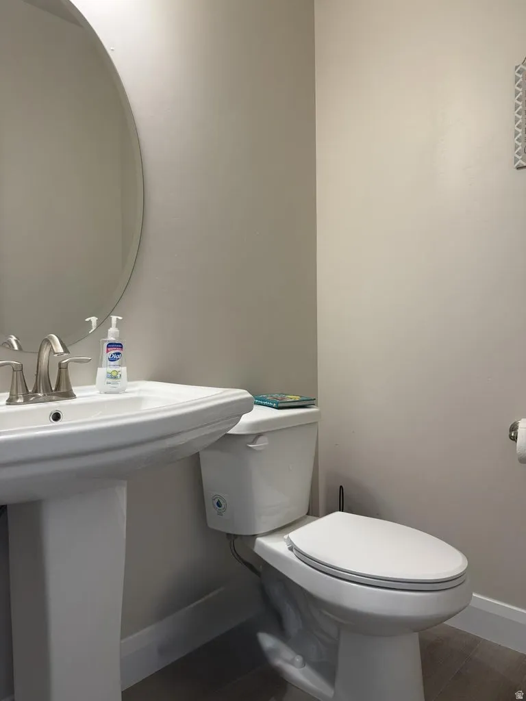 Half bath featuring toilet and baseboards