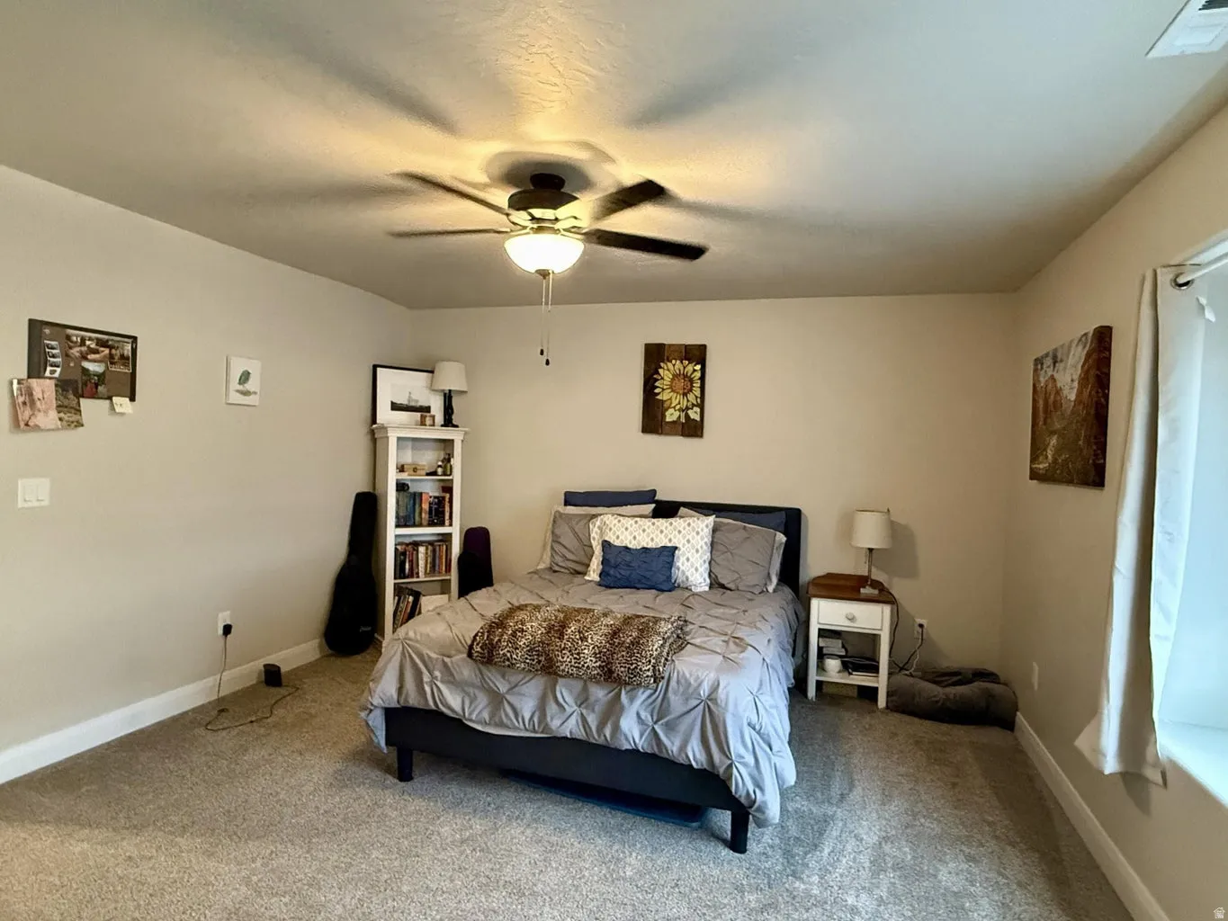 Carpeted bedroom featuring baseboards and ceiling fan