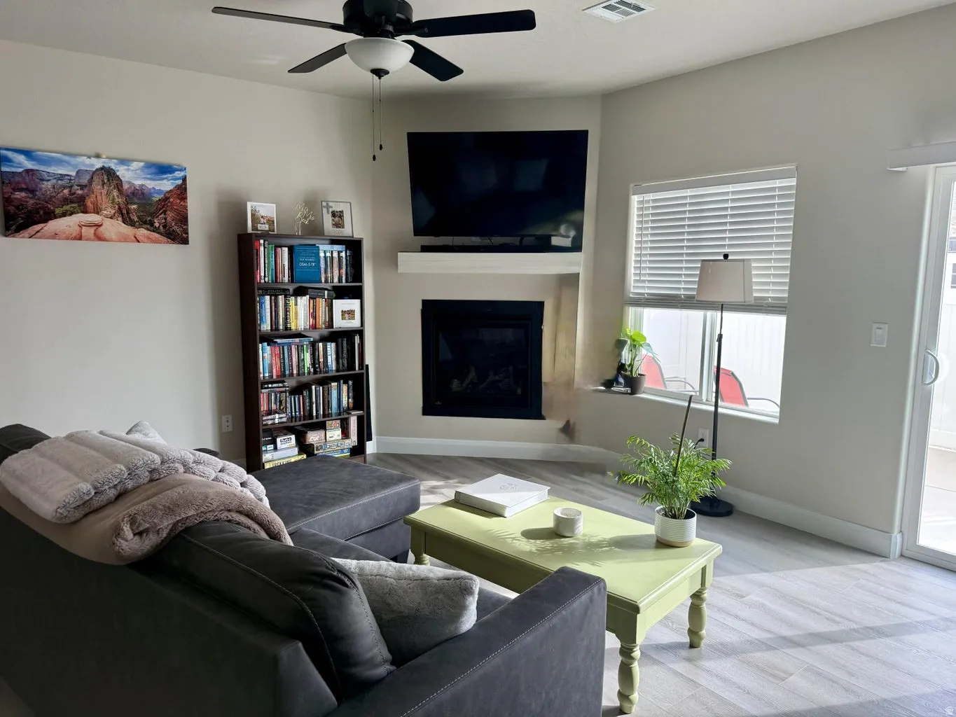 Living area featuring wood finished floors, a fireplace, and ceiling fan