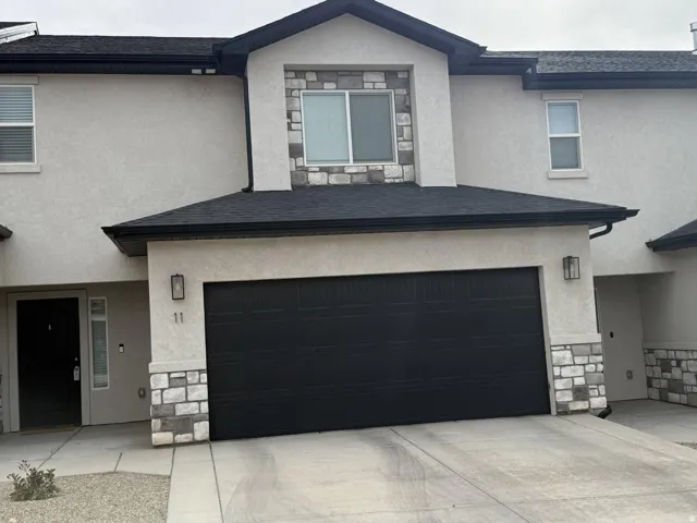 View of front facade featuring stone siding and stucco siding