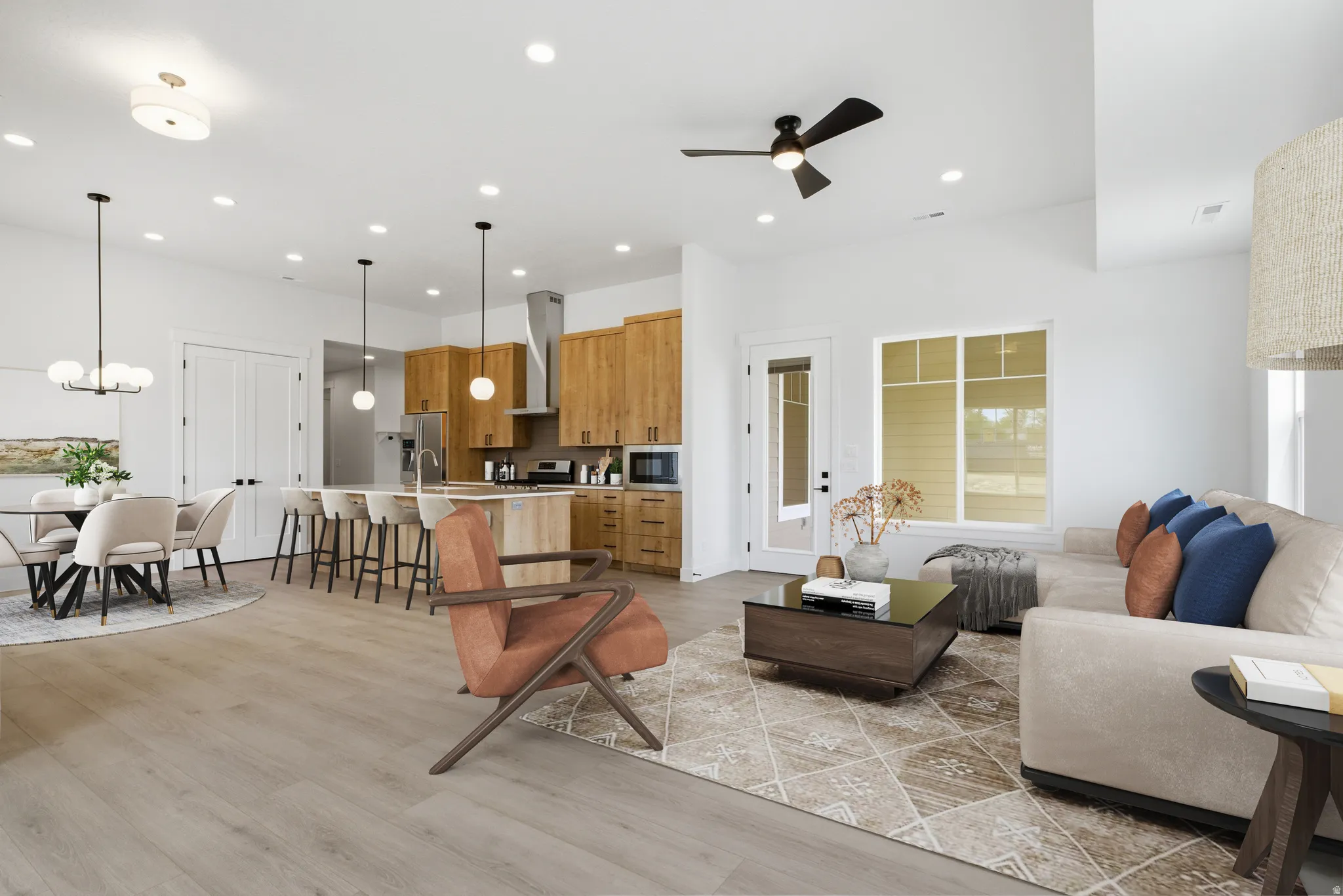 Living area featuring light wood-style flooring, ceiling fan, and suspended lighting