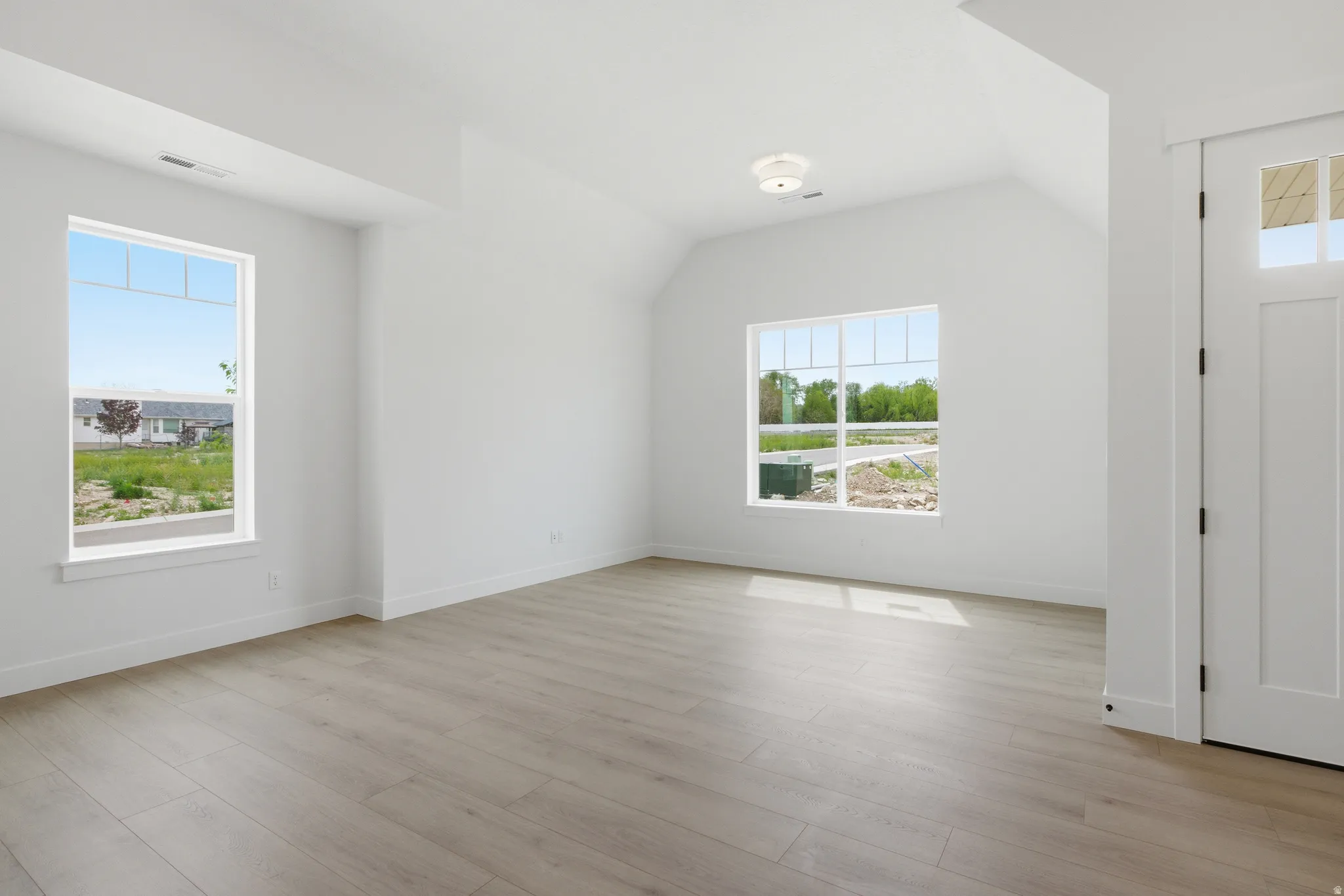 Entryway with vaulted ceiling and light wood-type flooring