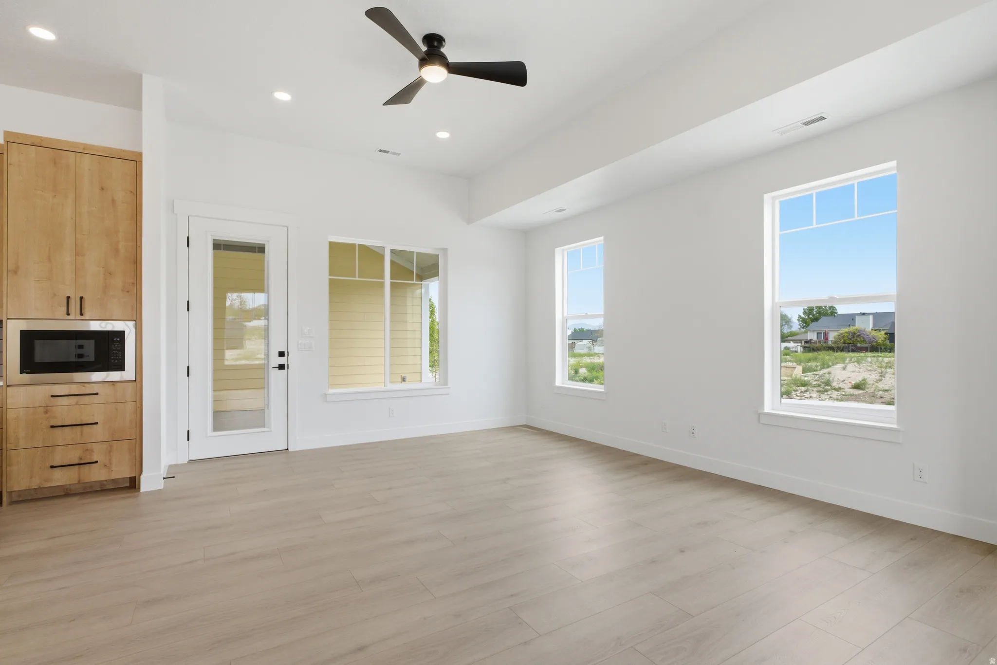 Unfurnished dining area featuring a ceiling fan, light wood-type flooring, and recessed lighting